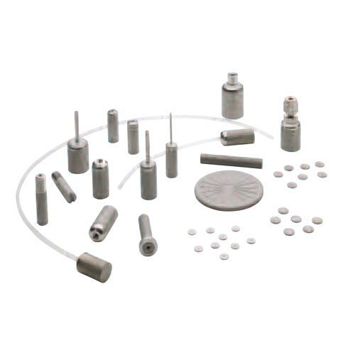 Various calibration weights and accessories arranged on a light background.