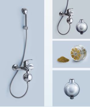 Wall-mounted shower fixtures with detachable shower head, alongside spherical christmas ornaments and a jar of yellow potpourri.