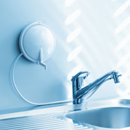 Modern bathroom sink with a faucet, under a wall-mounted mirror casting light stripes.